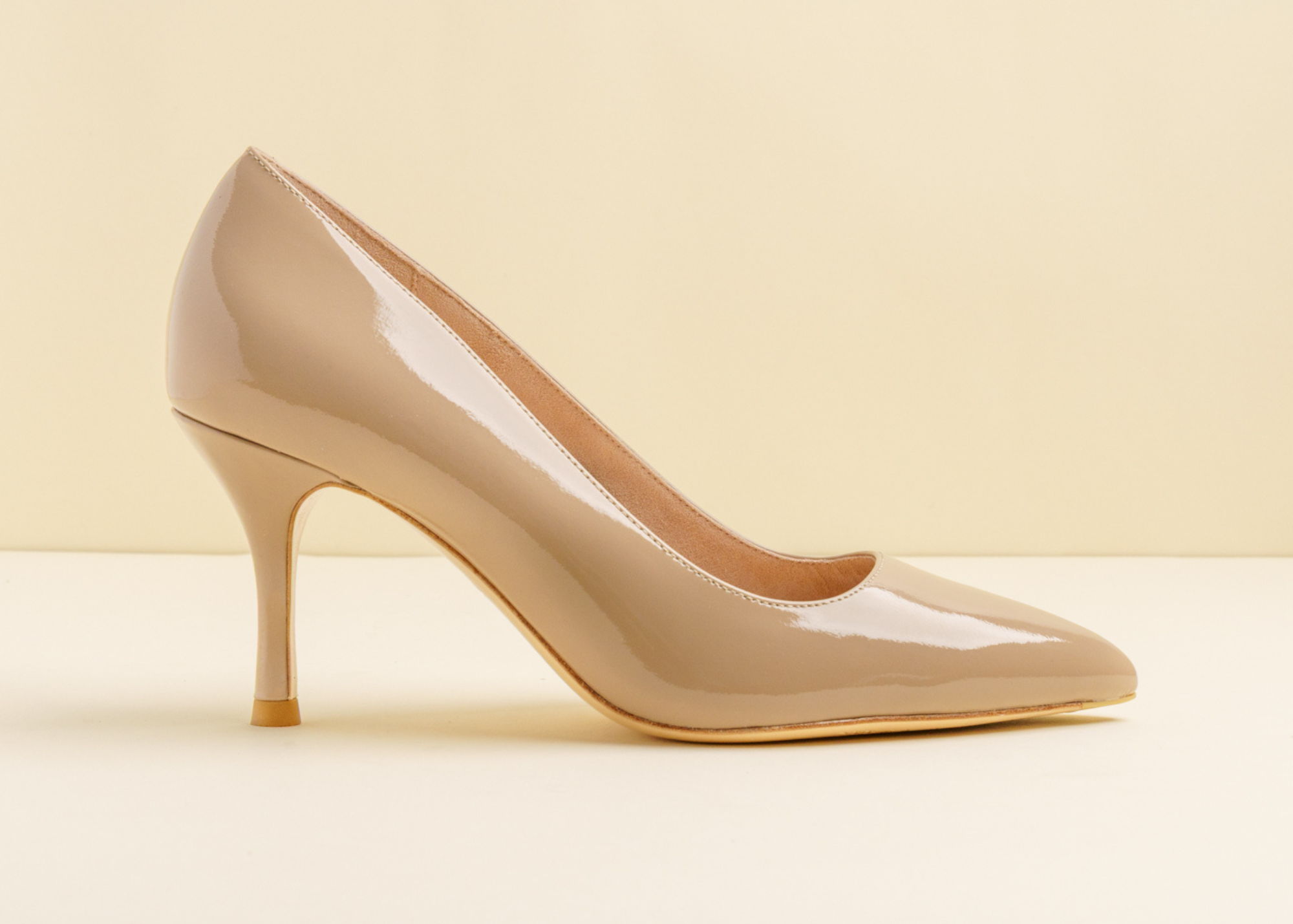 Beige high-heeled shoe on a light background.
