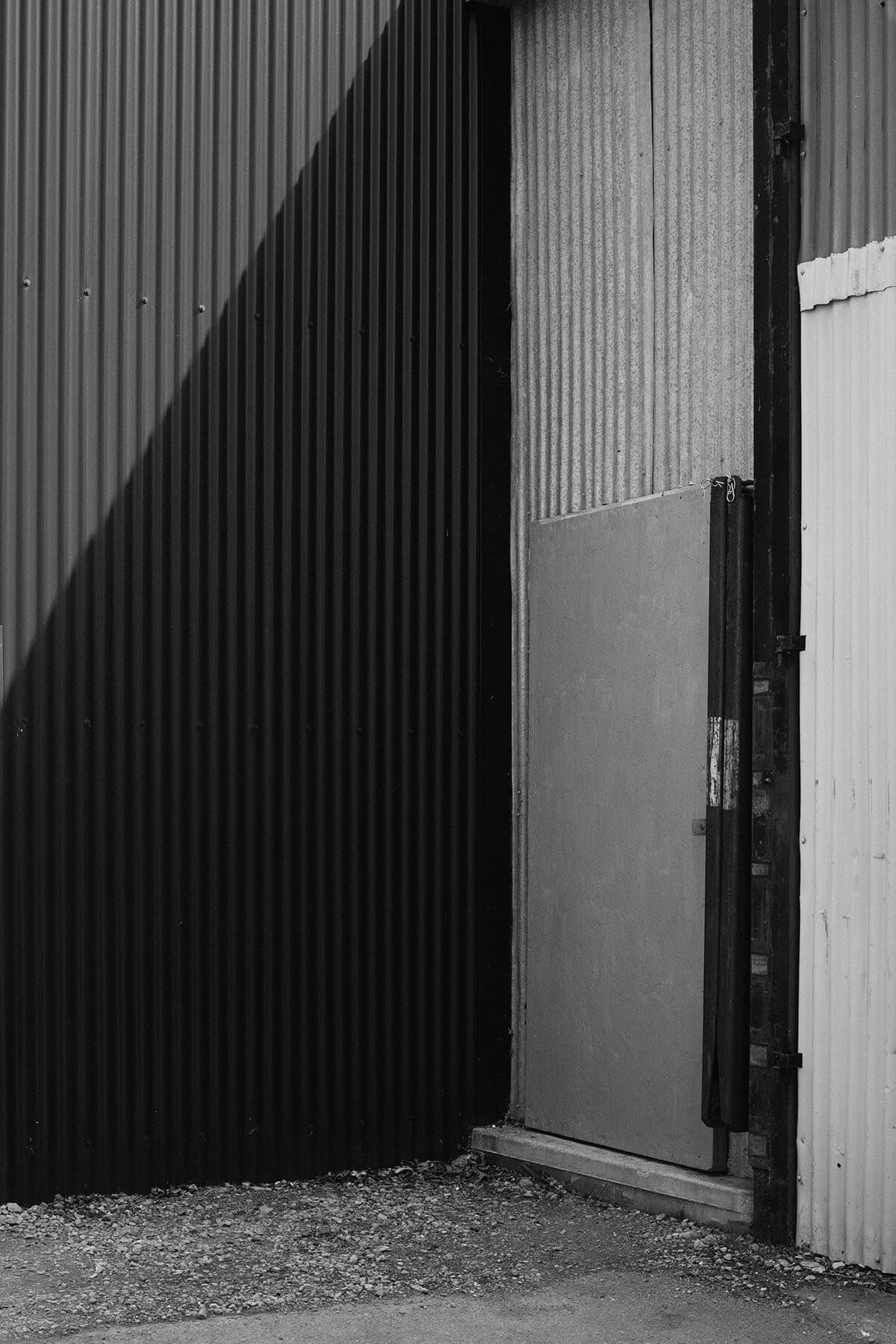 A corner of a building with contrasting textures and shadows.