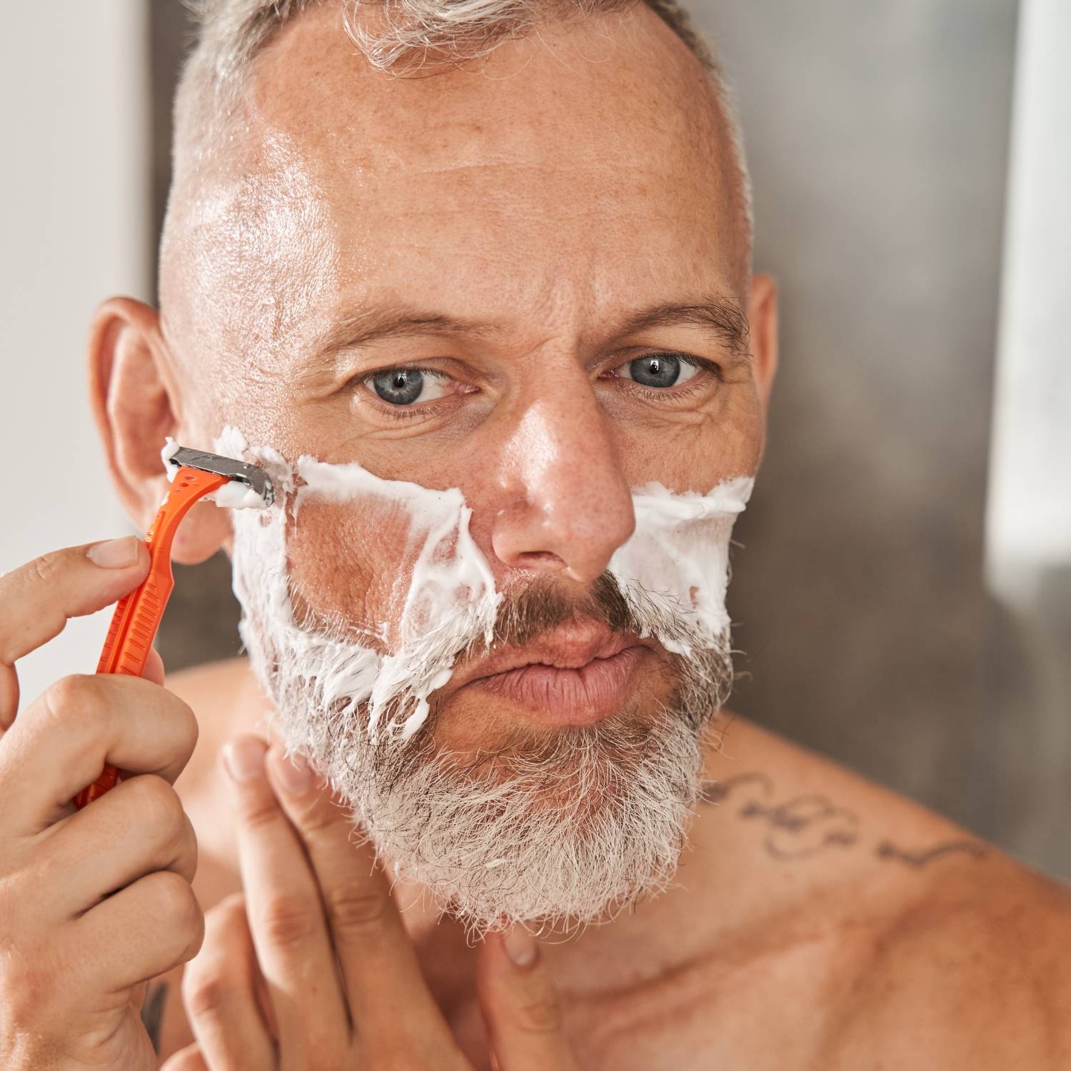 Mature caucasian male shaving his face 