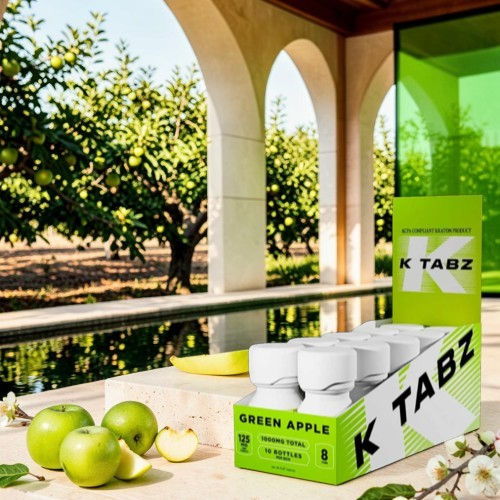 Box of K TABZ Green Apple tablets with apples outdoors.