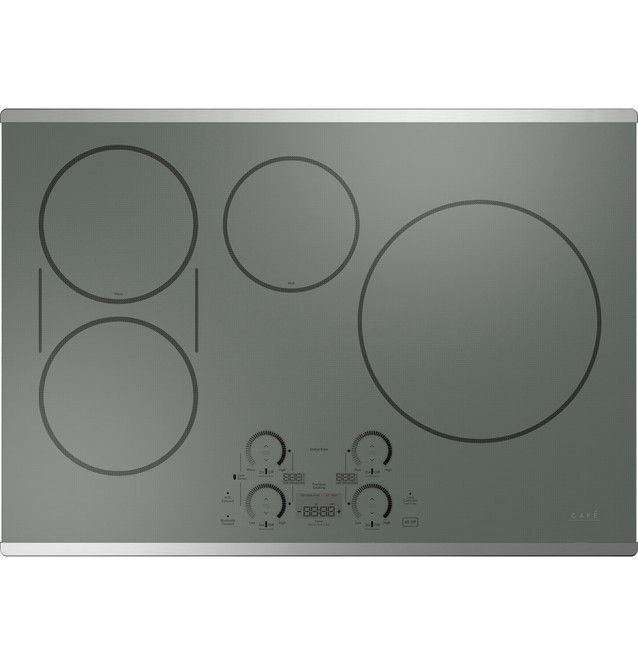 A modern glass top electric cooktop with multiple burners.