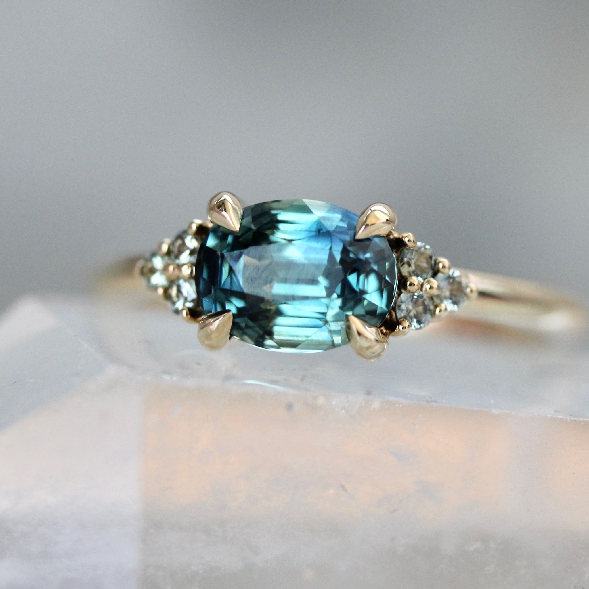 Oval cut teal sapphire east west engagement ring by Gem Breakfast
