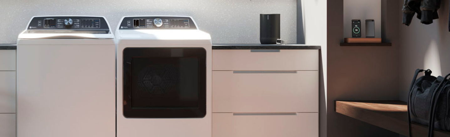 A modern laundry room with a washer, dryer, and storage cabinets.