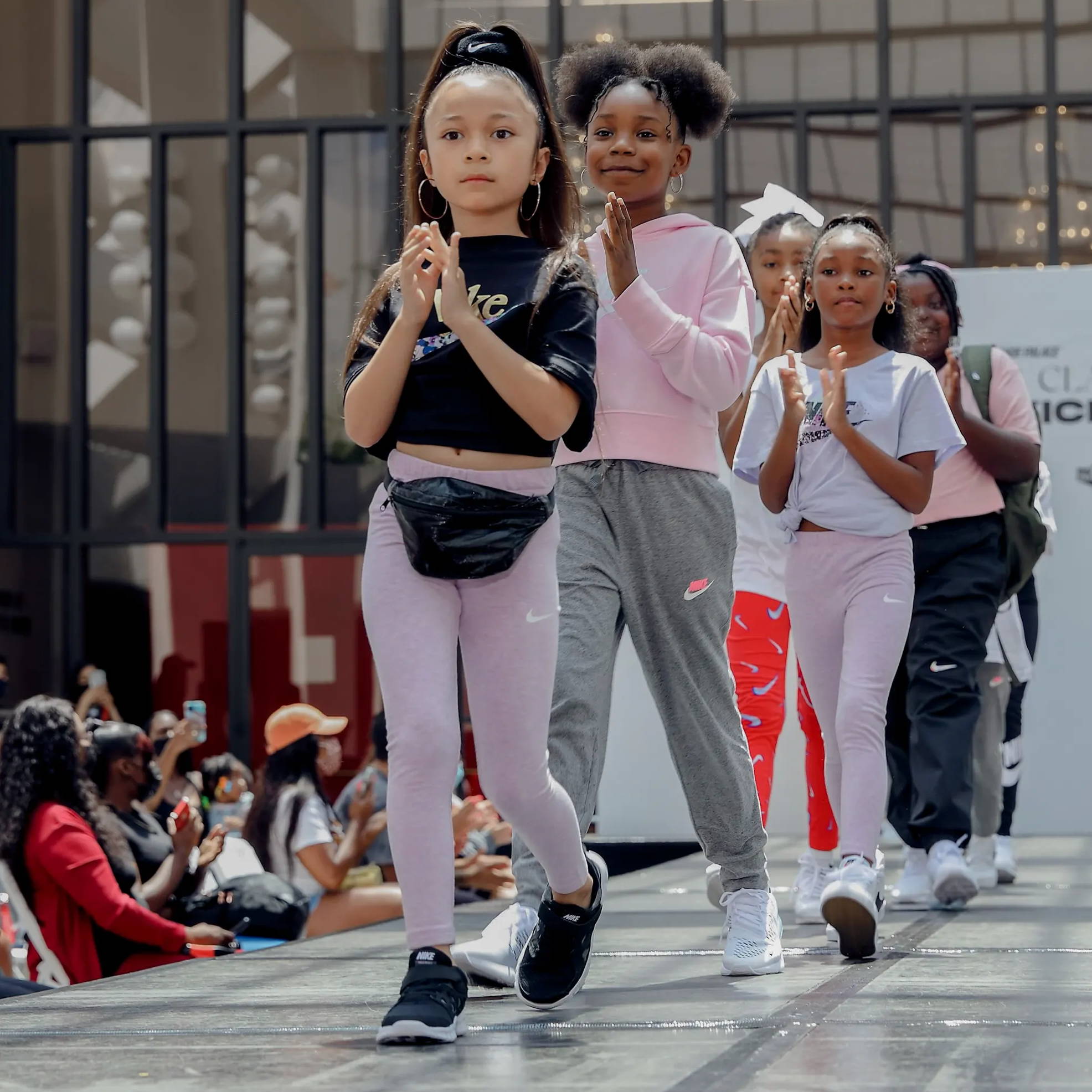 young girls walking on runway wearing nike gear