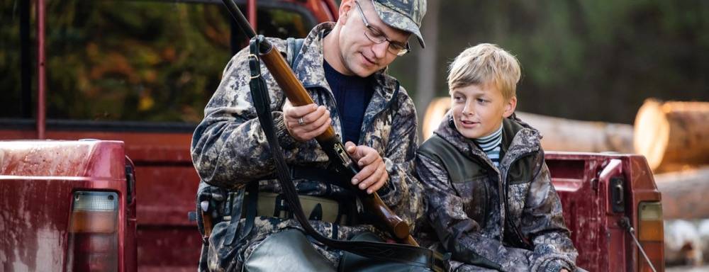 Father teaching son how to use shotgun