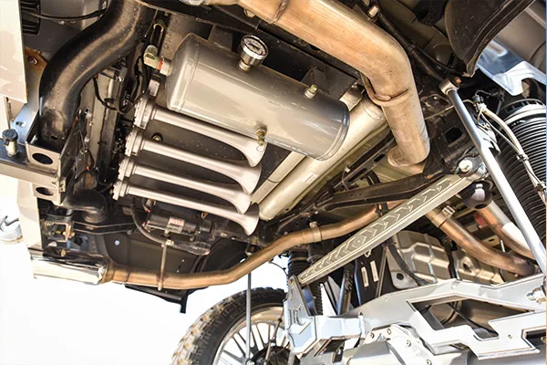 Close underbody view of silver air tank and train horn array installed on the lifted Dodge Ram 1500