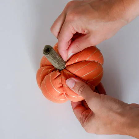 Hand Sewing the stem to the stuffed fabric pumpkin