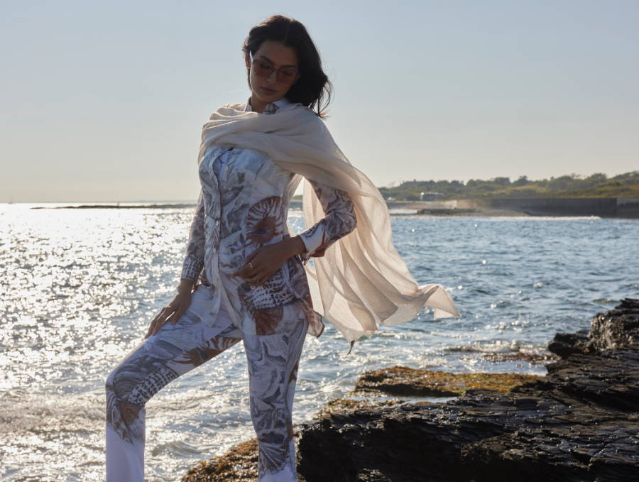 Woman wearing cotton shell brown and white printed blouse with stretch knit shell printed pants and cashmere wrap by the ocean in Newport, Rhode Island by Ala von Auerperg