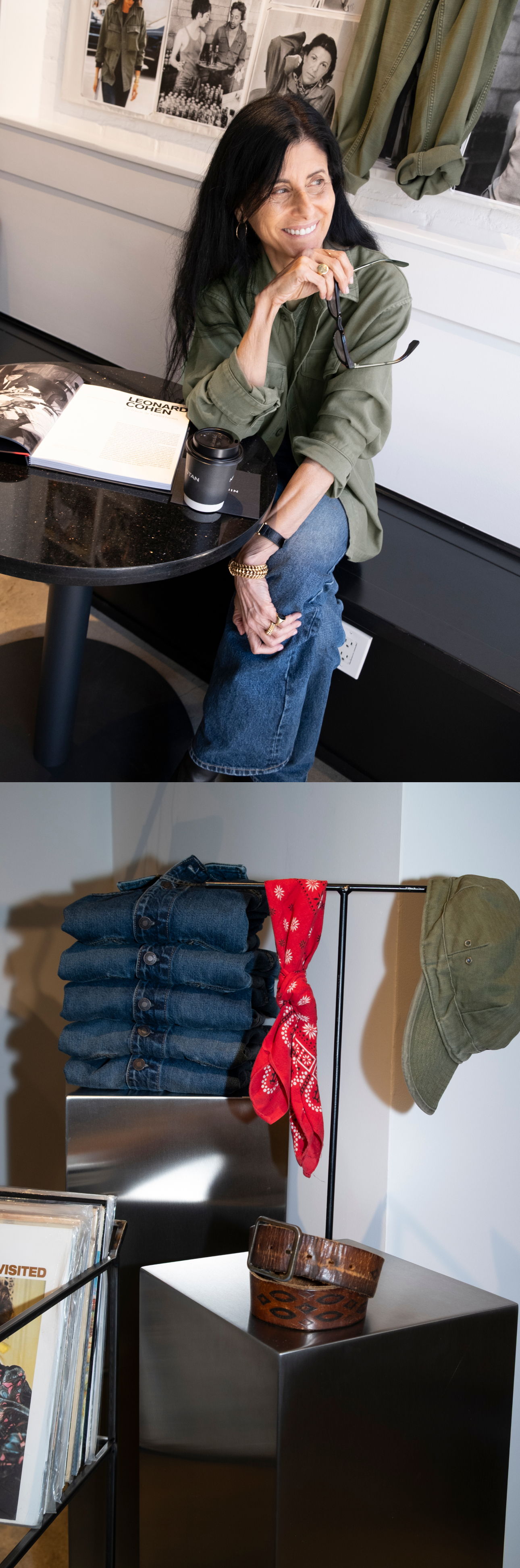 Woman sitting at a table with books and clothing displayed nearby.