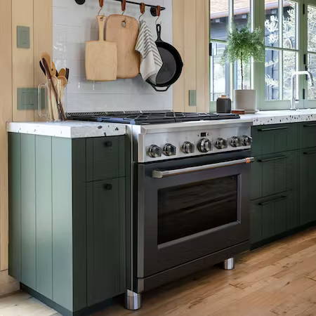 matte black professional range with sage green cabinets