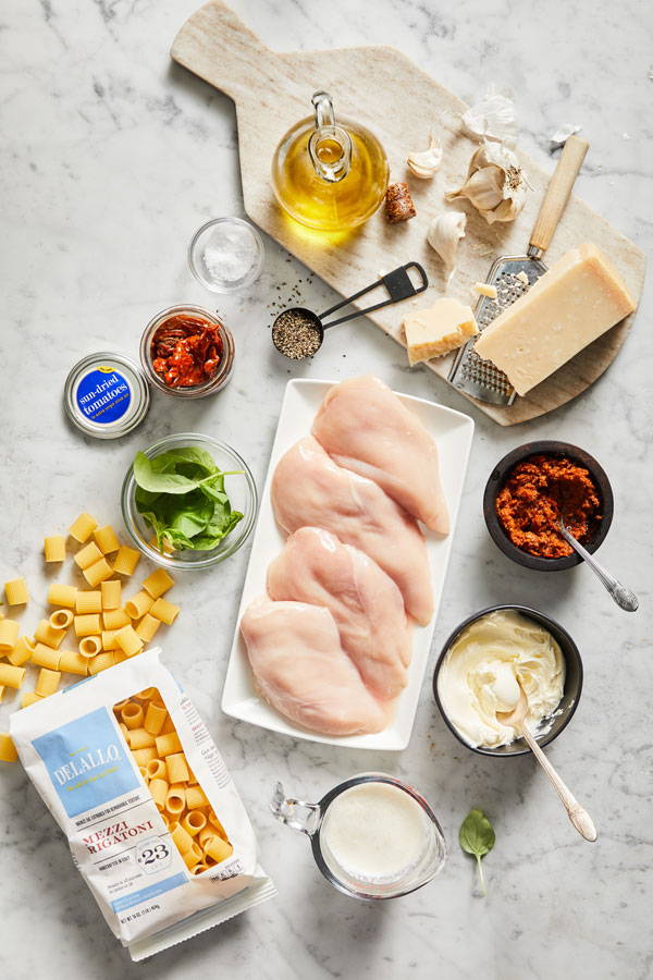 Ingredients for Marry Me Chicken recipe laid out of marble table