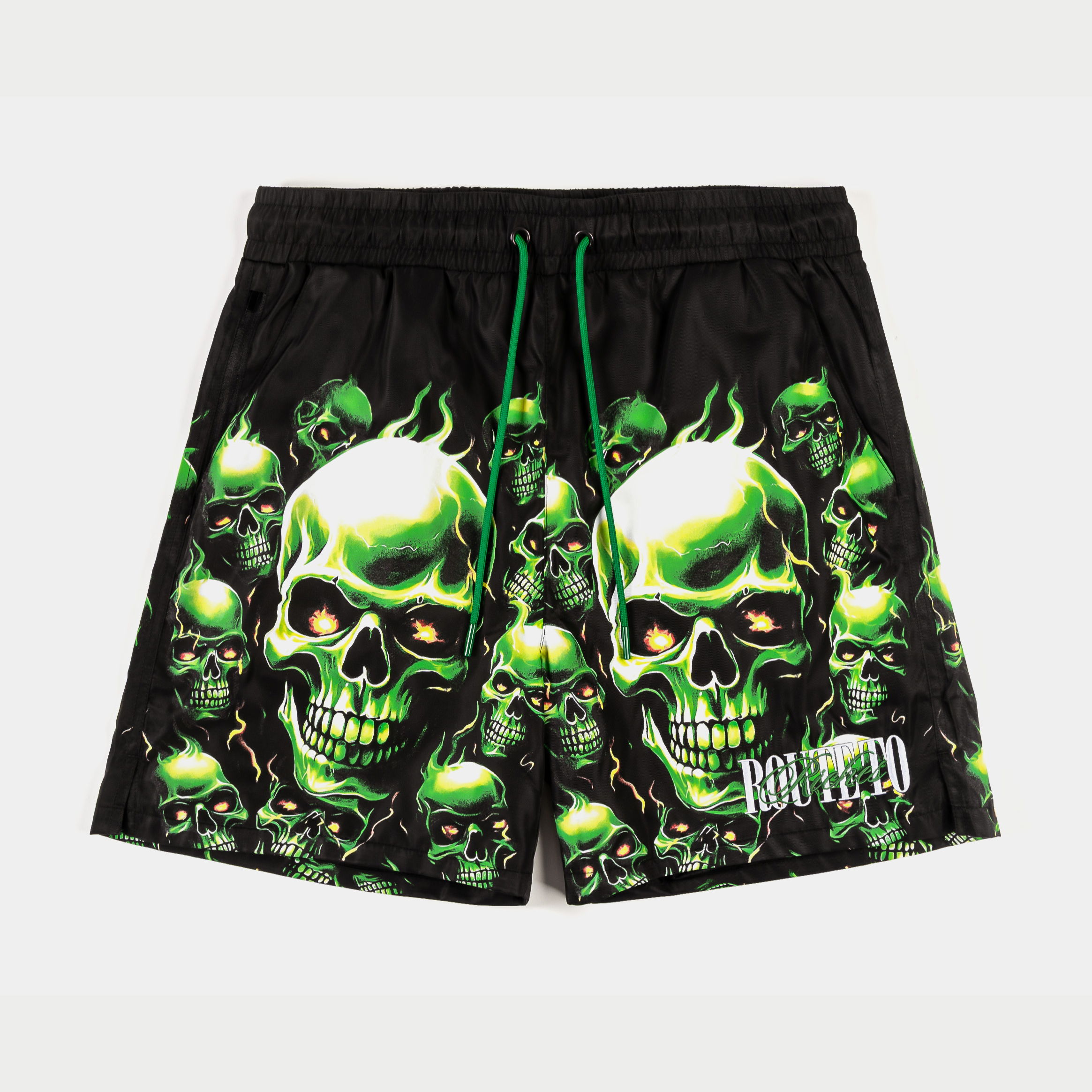 Black swim trunks with green skull designs and drawstring.