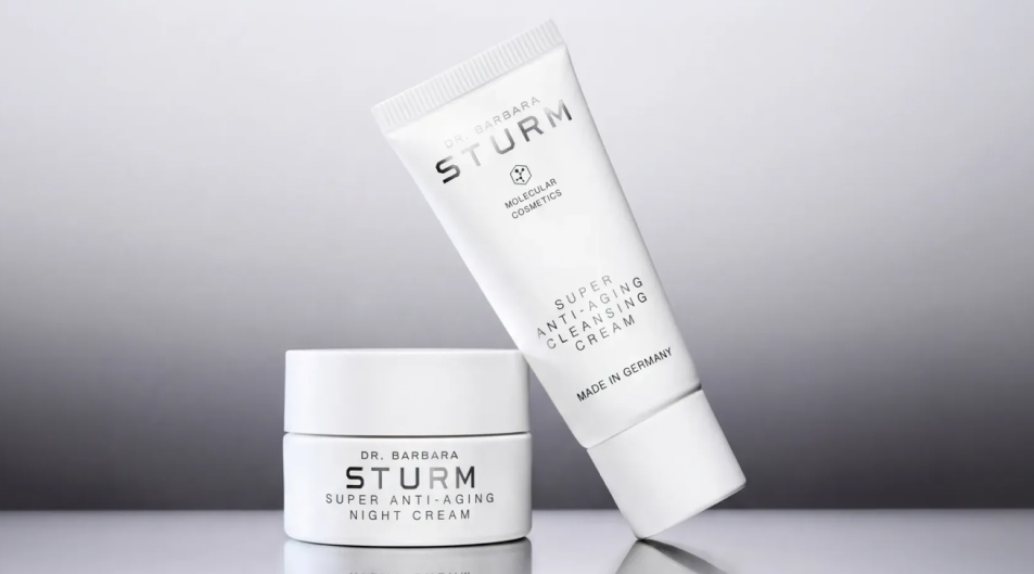 Two skincare products on a reflective surface, one jar and one tube.