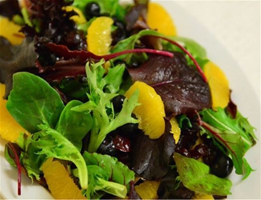 A colorful salad with mixed greens and orange segments.