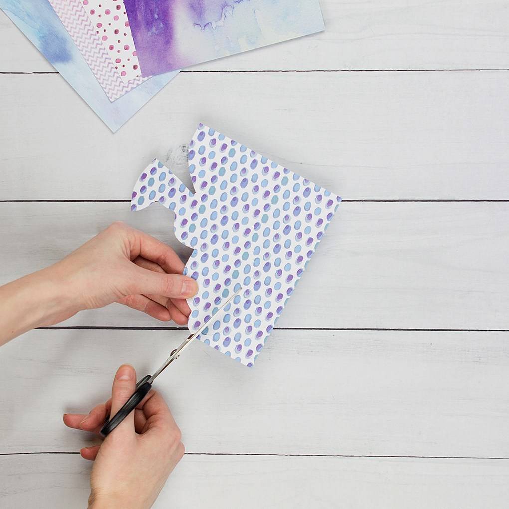 Person cutting gout bunny shape from purple coloured card.