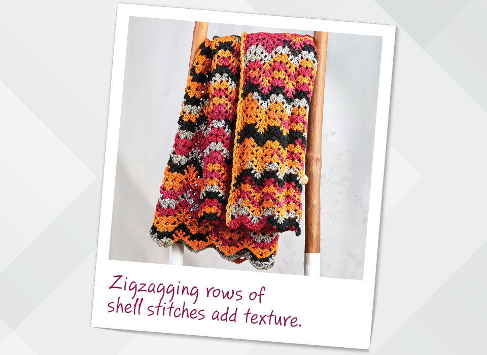 Colorful crocheted fabric with Zigzagging rows of shell stitches add texture.