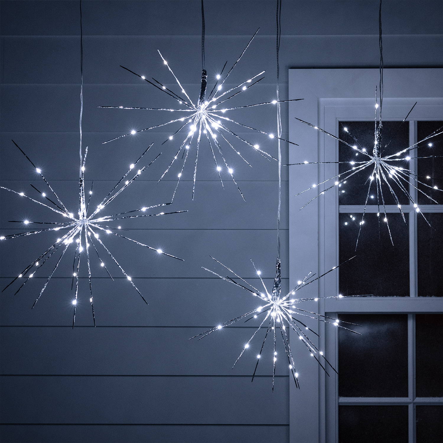 4 Sparkling starburst lights in an outdoor setting at night.