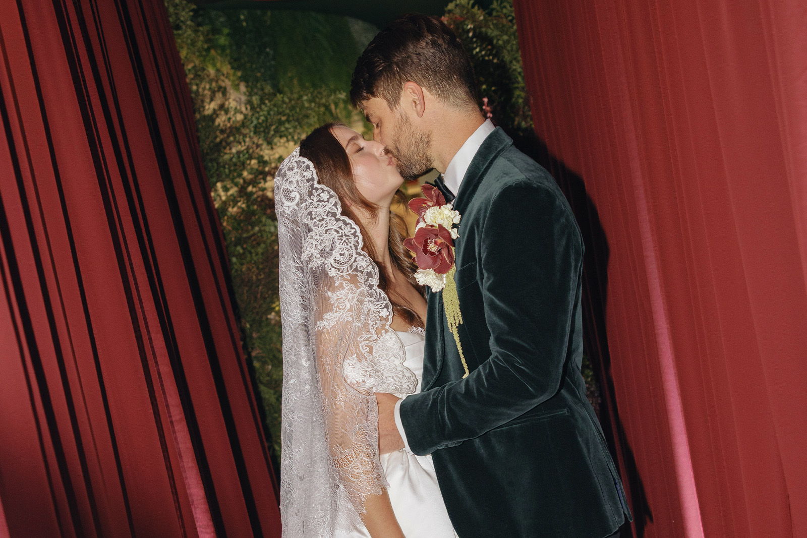 Bride and groom sharing a kiss in an elegant setting.