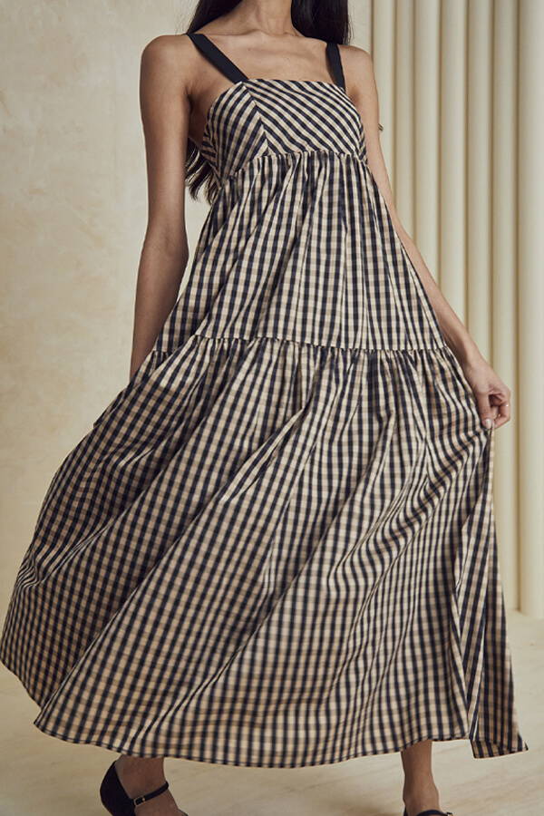A look book image of a model wearing the Hunter Bell Easton Dress Black and Brown Gingham.