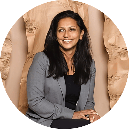 Saloni Doshi in a gray blazer against a textured background.