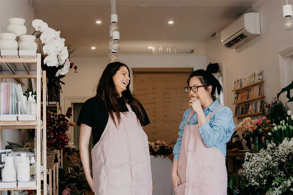 Carla and Jess of The Ivy League in CULTIVER Jude Linen Aprons.