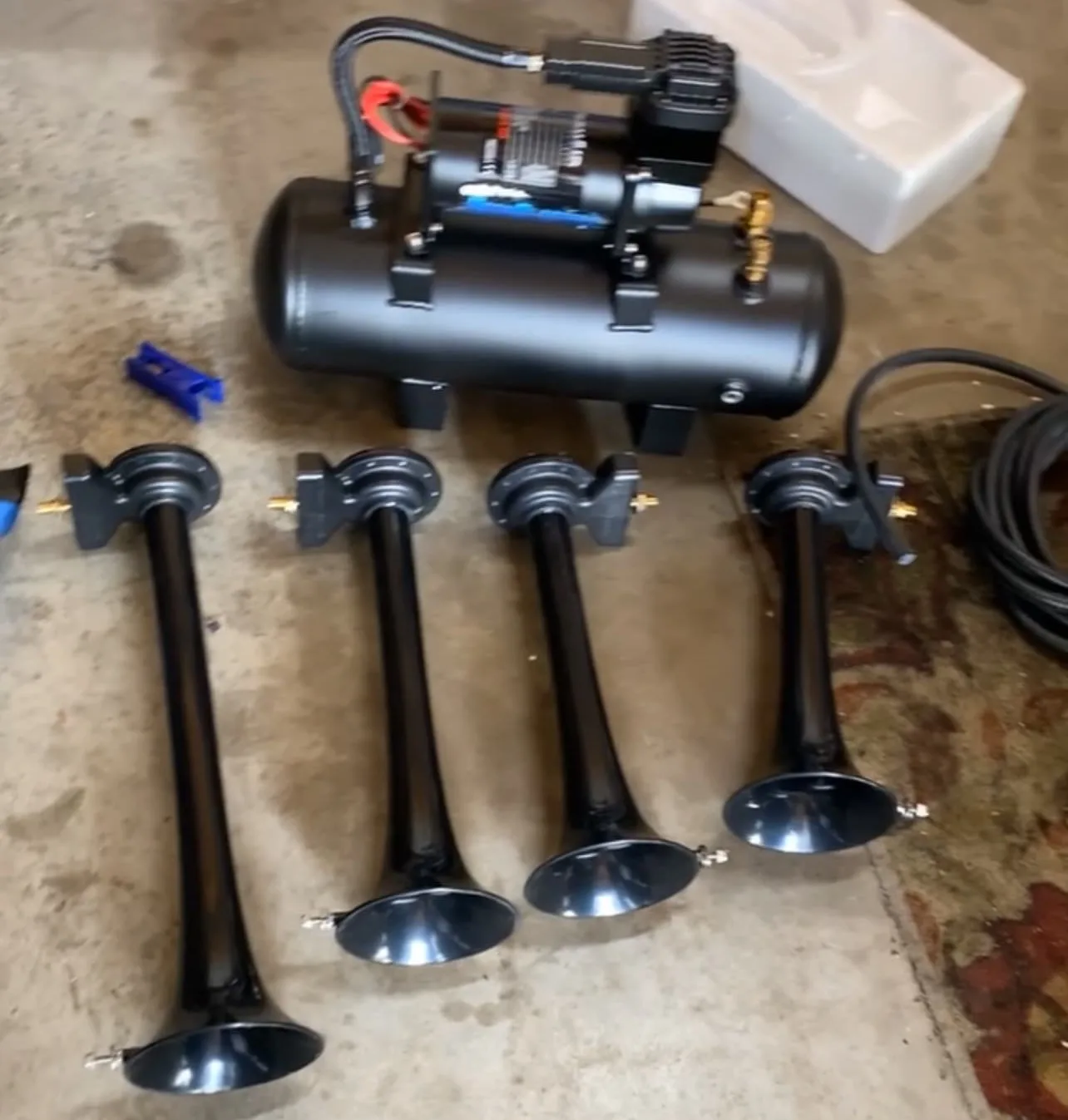 Black train horn kit with air tank and four horns on floor