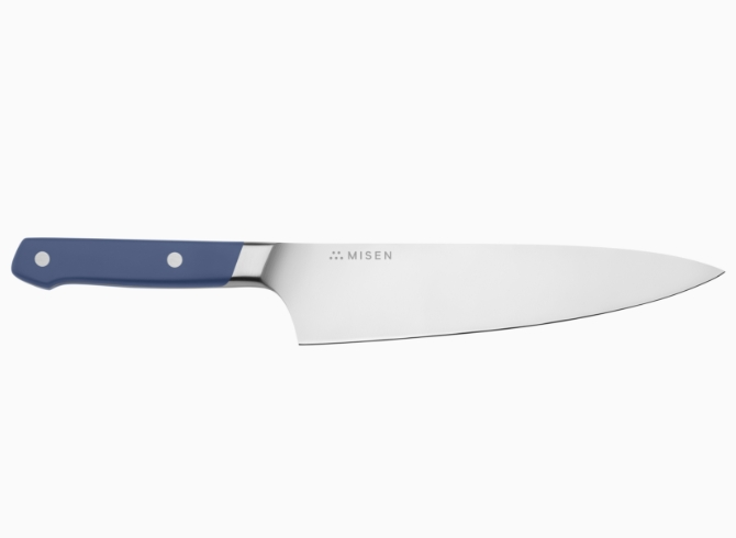 A blue Misen Chef’s Knife seen from the side, with the Misen logo visible at the base of the knife’s spine.