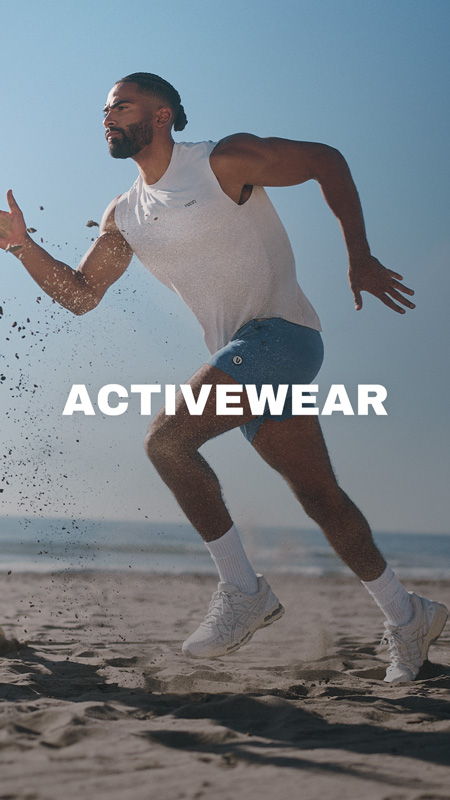 Man running on the beach in activewear.