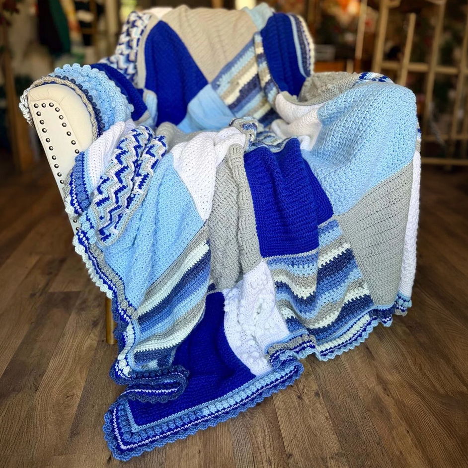 A cozy blue and white knitted blanket draped over a chair.
