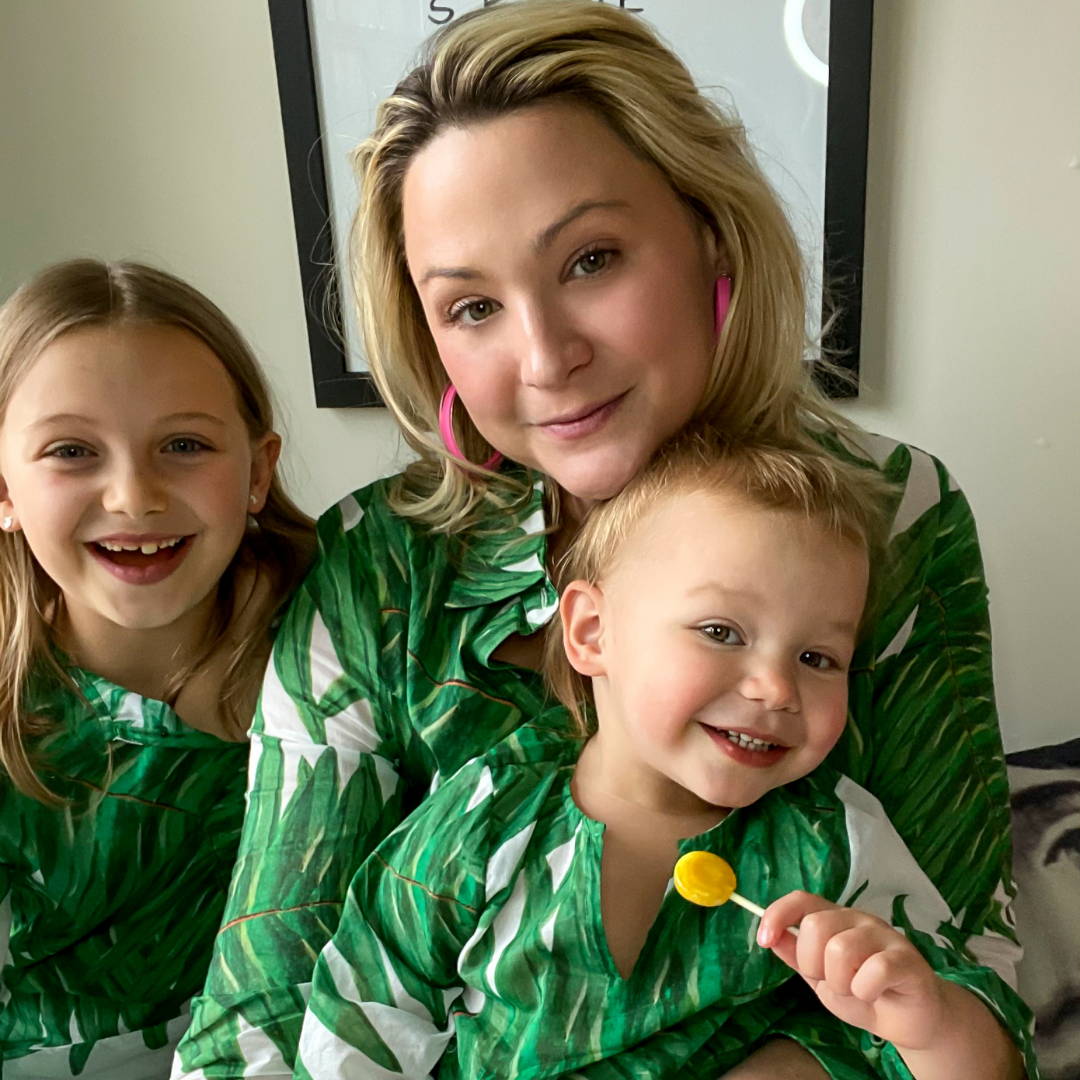 Sunny and her kids wearing matching green palm printed cotton dresses and shirts by Ala von Auerserg
