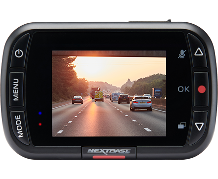 Dashboard camera displaying vehicles on a highway during sunset.