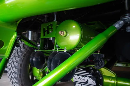Close-up underside view of black horn bells and green tank mounted under Joe's 2017 Chevy Silverado 2500HD, install photo 4