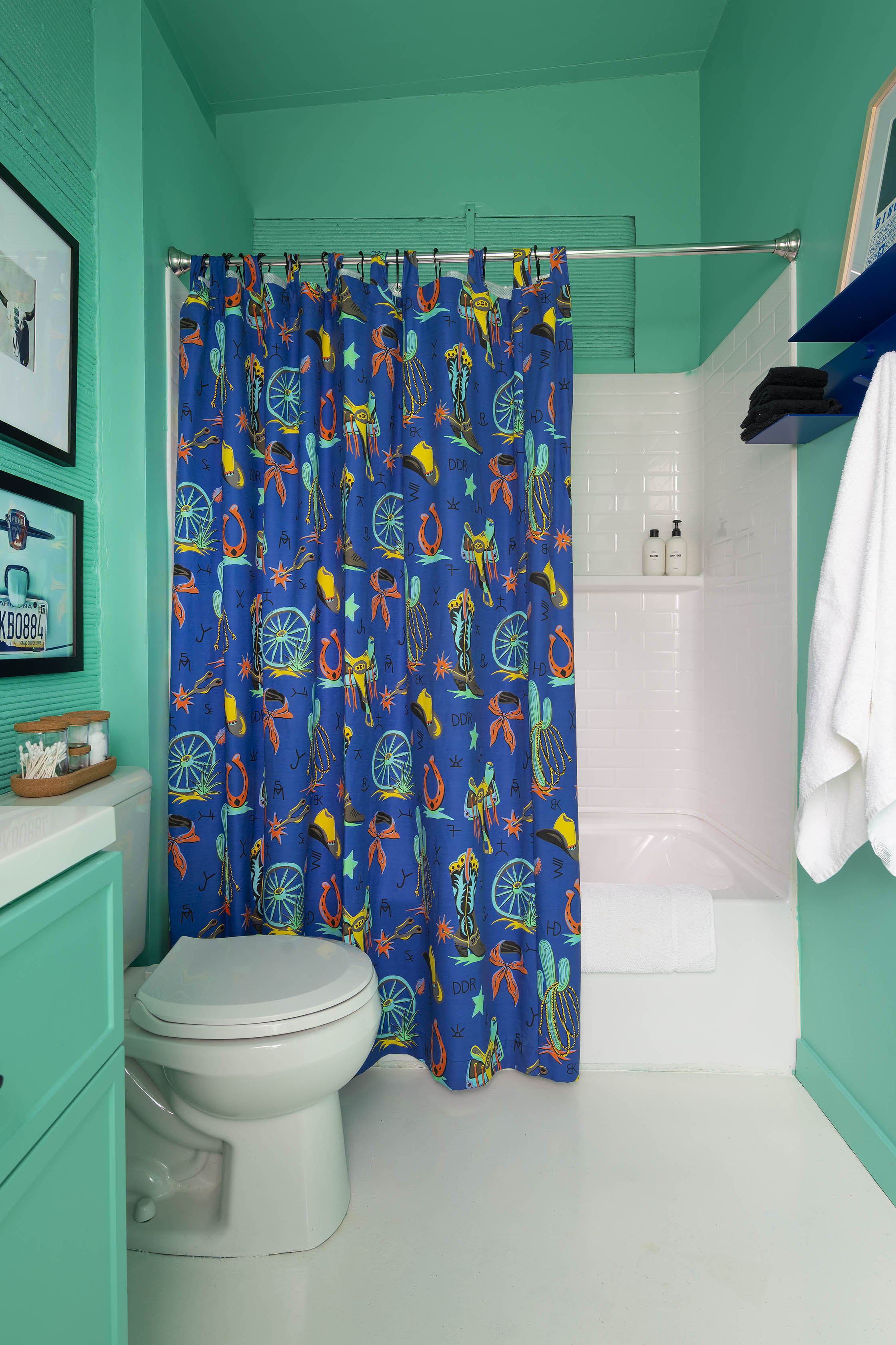 Green bathroom with western shower curtain in the DDR Casita at The Halles in Round Top, Texas.