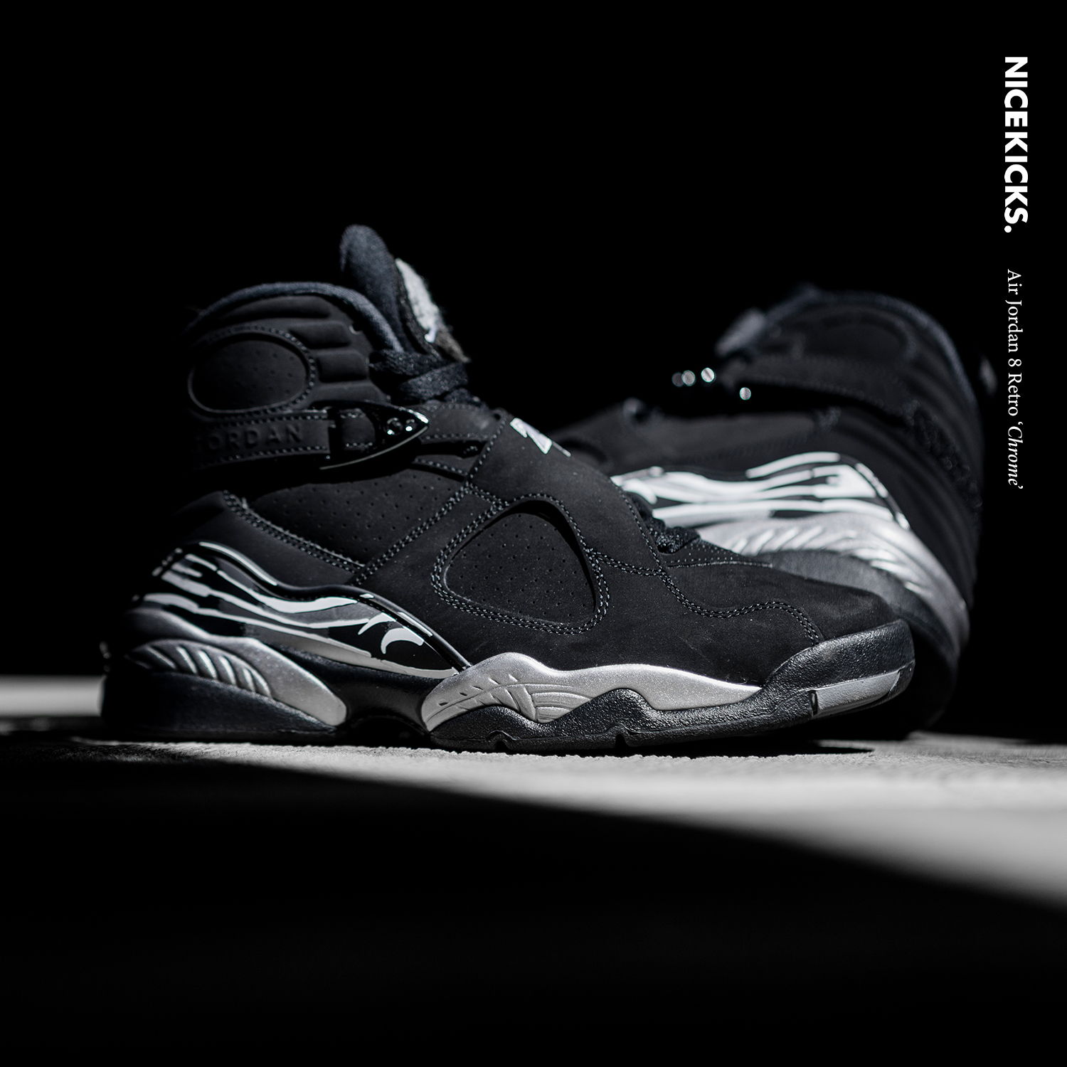 Black and silver athletic shoes on a dark background.