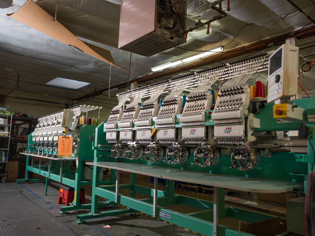 A row of green multi-head Findlay embroidery machines.