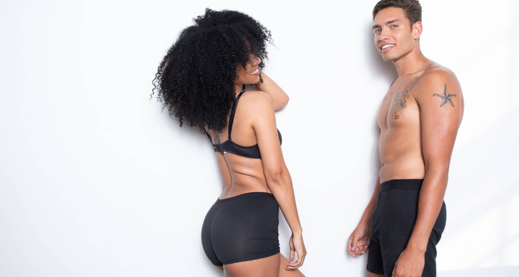 A man and woman stand wearing perfect-fitting WAMA underwear thanks to an underwear size chart.