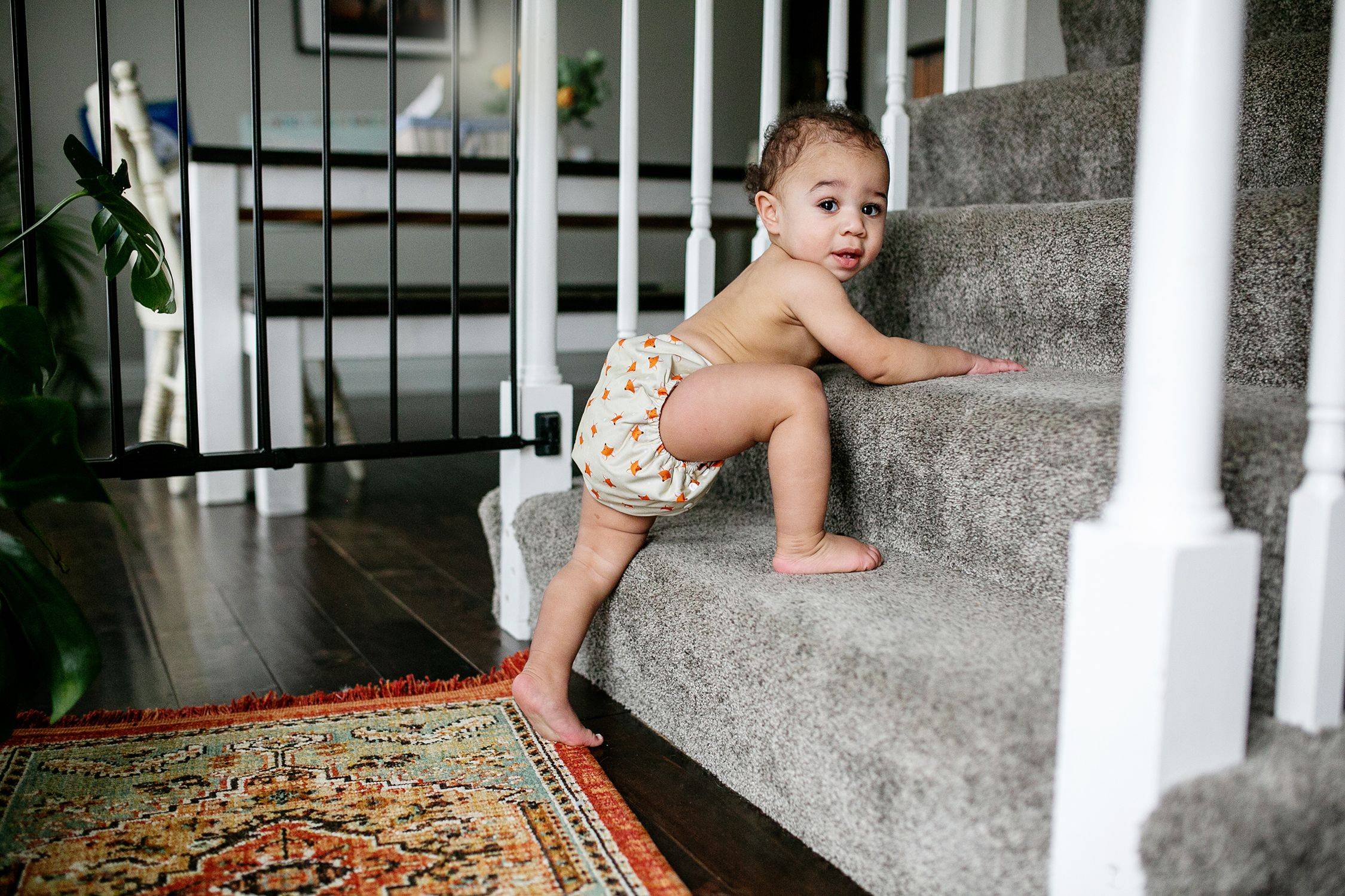 Baby climbing up the steps in our latest design from Simple Being, an Ocean Animals themed cloth diaper with whimsical starfish.