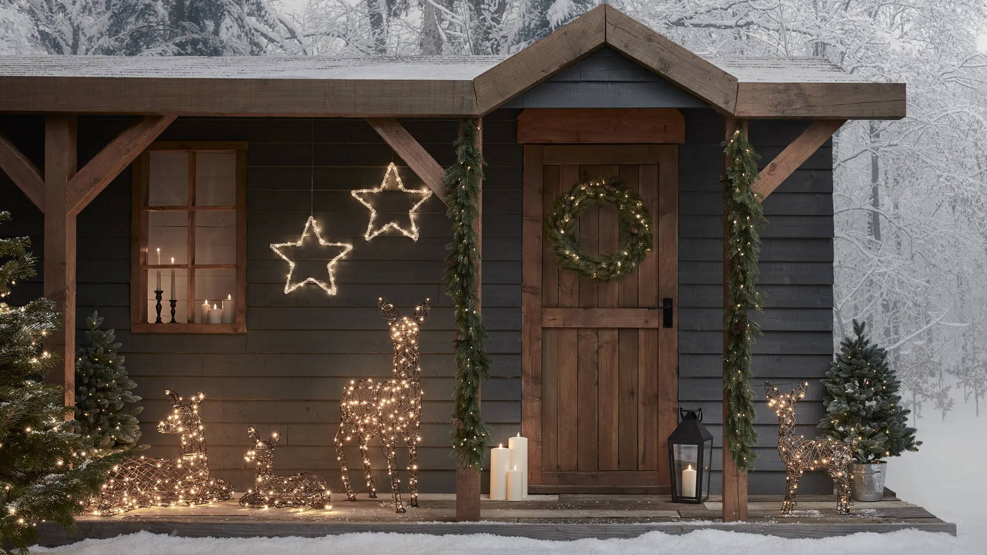 Devant de porte décoré par des rennes lumineux, des étoiles lumineuses, des guirlandes  et couronnes de Noël. 