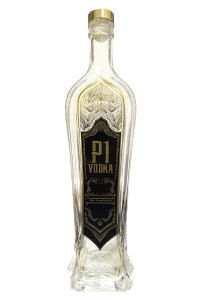 Clear vodka bottle with decorative label and gold cap.
