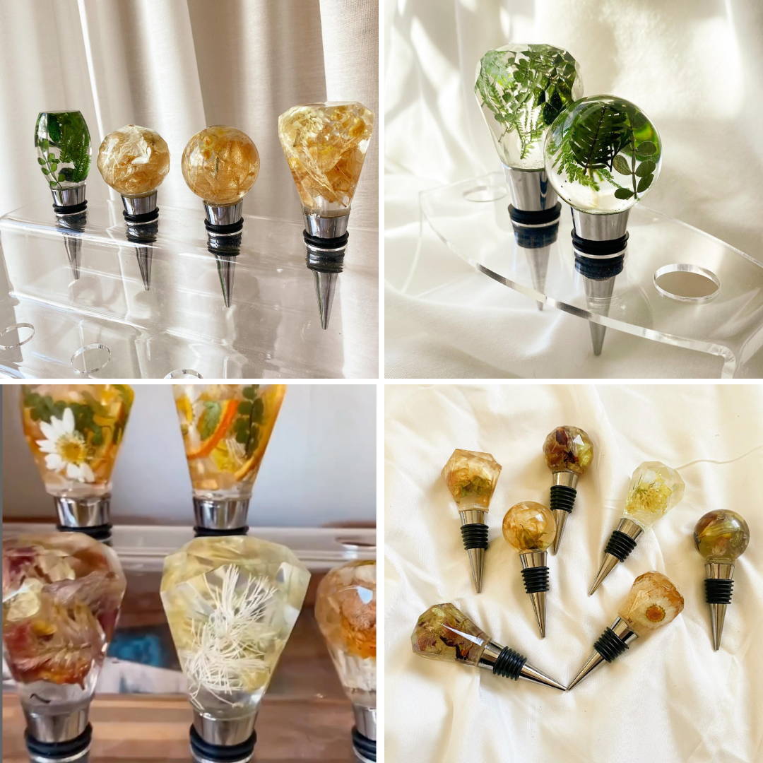 four different wine stoppers with dried flowers and green botanicals encapsulated in epoxy resin