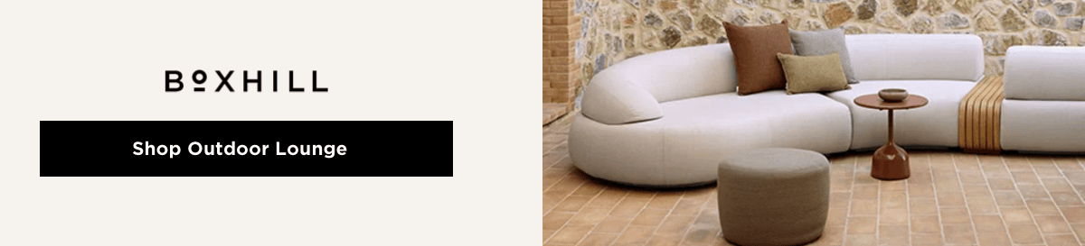 Boxhill “Shop Outdoor Lounge” CTA with a curved white modular outdoor sectional, accent pillows, and a side table on a brick patio. 