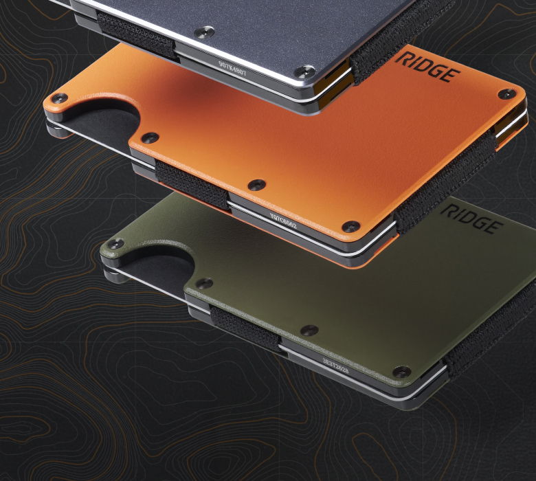 Three stacked metallic wallets in different colors on a dark background.