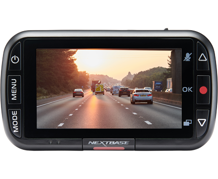 Nextbase dash cam displaying highway traffic at sunset.