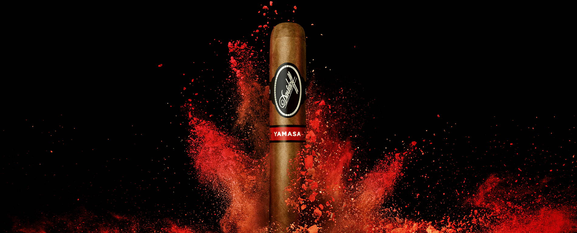 A Davidoff Yamasá cigar standing upright in front of a splash of bright red colour.