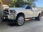 White lifted Ram 3500 Heavy Duty single cab dually with chrome wheels and Bandit M/T tires on driveway