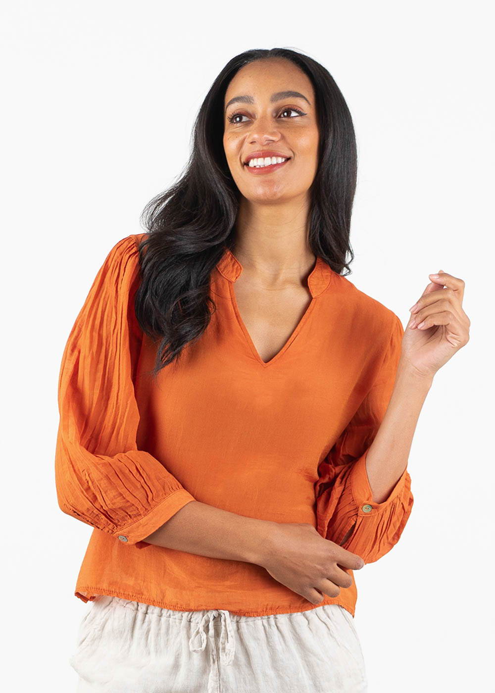 A model wearing a tomato red cotton blouse with a v neck and 3/4 sleeves