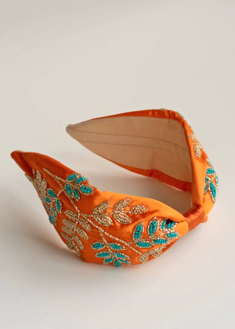 A orange silky headband with blue and gold embroidered beading leaf detailing