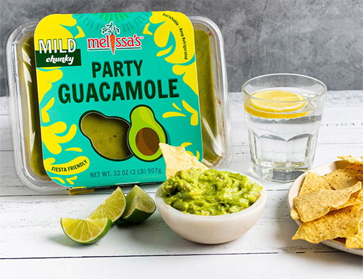 Party guacamole container with chips, lime, and a glass of water.