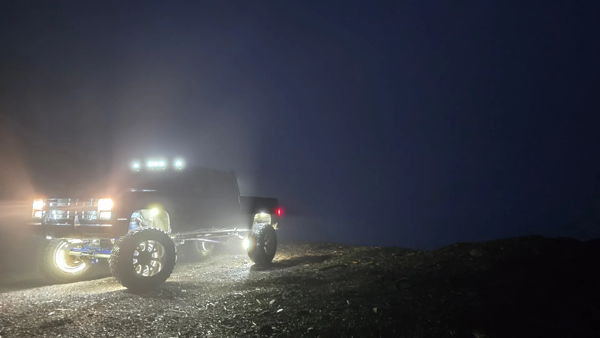 Foggy night view of Joseph's 1985 Chevy K30 with illuminated wheels and roof lights, install photo 3