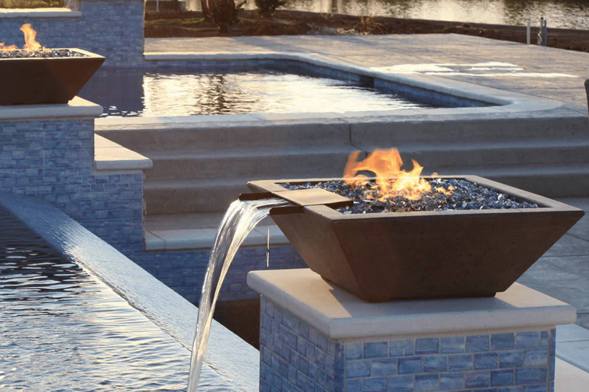A square shape fire/water bowl placed on a pool that is crafted by hand on patina finish